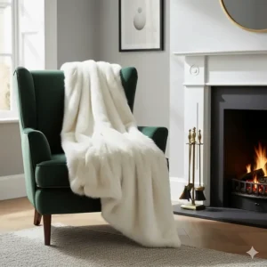 An ivory faux fur throw elegantly draped over a velvet armchair next to a fireplace, highlighting British interior styling.