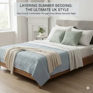 A styled bed showing how to layer a thin blue summer blanket with white flat sheets for a versatile British bedding setup.