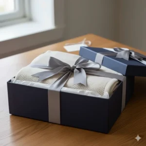 A luxury throw blanket presented in a high-end gift box with a silk ribbon, ideal for housewarming gifts.