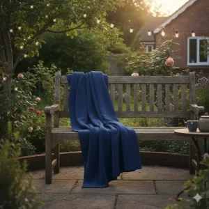 A soft navy fleece blanket placed on a wooden garden bench for a cool British summer evening.
