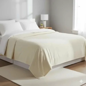 A heavy cream weighted blanket laid out across a bed with white cotton linens.