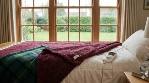 A clear infographic showing care instructions for a thermal blanket, including symbols for a 30-degree gentle machine wash and a reminder to remove the controller.