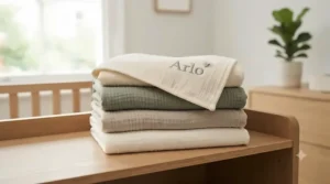 A smiling baby swaddled snugly in a soft, personalised nursery blanket.