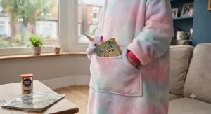A neatly folded unicorn hooded blanket tied with a festive gift ribbon, ready to be given as a birthday present.