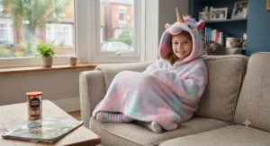 Illustrated diagram showing the length and relaxed fit of a one-size-fits-all wearable unicorn hooded blanket for kids.