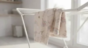 Freshly laundered pink unicorn blanket hanging softly over a laundry airer, highlighting machine-washable quality.
