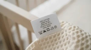 Illustration of laundry symbols on a clothing tag for washing baby cellular and muslin blankets.