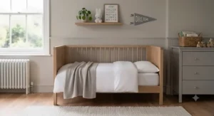 Neutral grey toddler bed blanket styled in a scandi-inspired children's room interior.