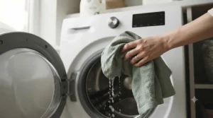 Durable toddler bed blanket being removed from a washing machine, highlighting easy machine washability for busy parents.