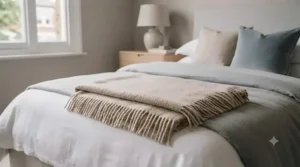 King-size bed styled with a lightweight all season blanket layered neatly under a duvet for chilly autumn nights.