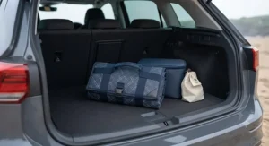 A neatly folded beach picnic blanket stored compactly in the boot of a car ready for a weekend trip.