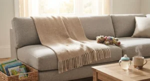 A durable, snag-resistant multi-season throw spread across a family lounge sofa, designed to withstand daily use by children and pets.