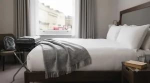 A soft, hypoallergenic all season blanket for travel spread across a hotel bed.