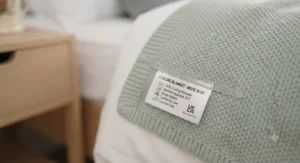 Care label and hem detail showing a machine-washable cooling blanket suited for everyday home use.