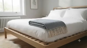 A contemporary grey all-season blanket styled on a minimalist double bed to complement British interior decor.