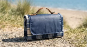 Lightweight foldable picnic blanket featuring an adjustable carry strap for easy travel hiking.
