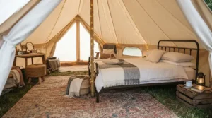 A stylish glamping setup featuring a comfortable camping blanket for car camping over a wooden deck chair