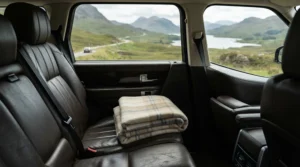 A compact travel blanket lying on the back seat of a car during a scenic road trip